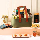 Indulgence Treasure Gourmet Hamper | Gift Hampers Online featuring artisanal sweets, dry fruits, biscotti, and honey in a premium green tote bag.